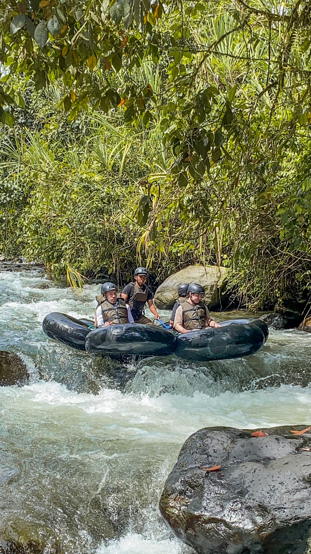Tubing group floating through a forest river